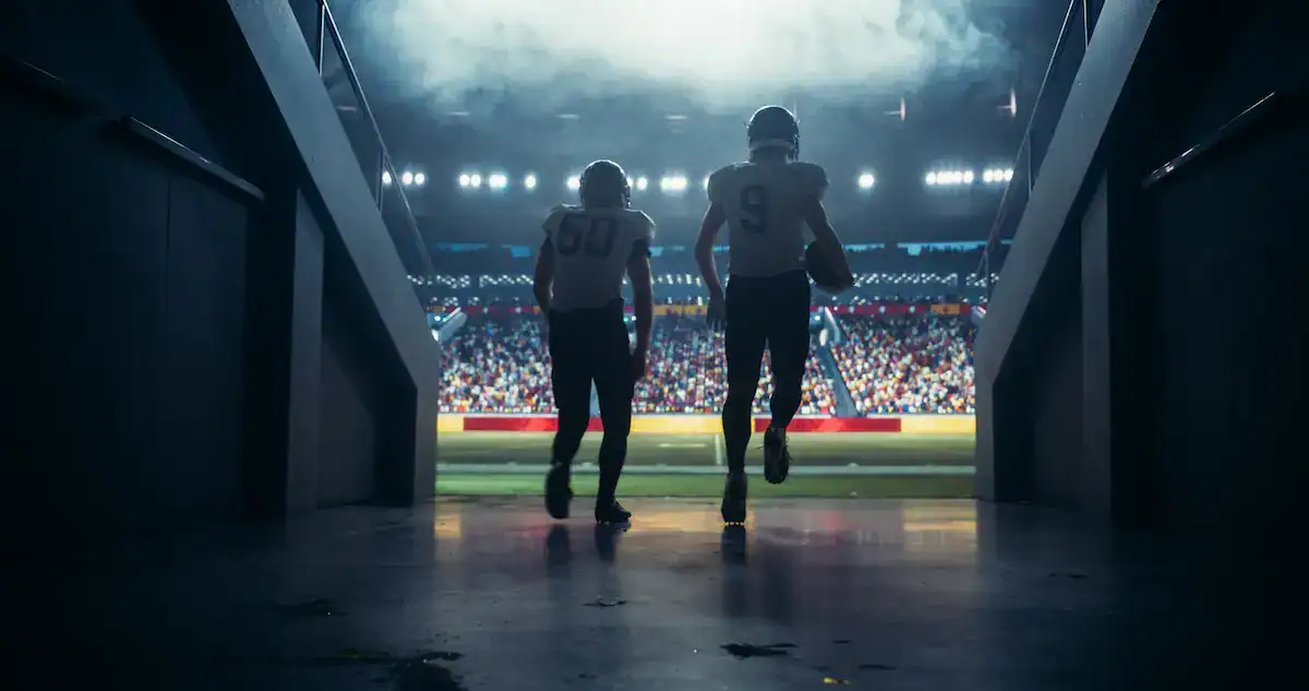 College football players running out of the tunnel onto the field