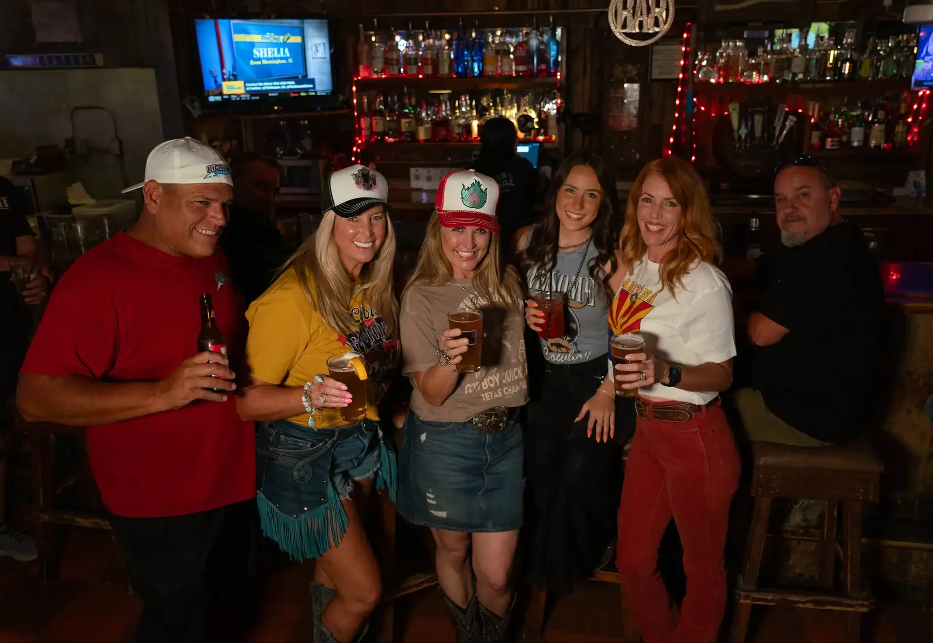 Happy customers of Q Bar & Grill standing in front of the bar.