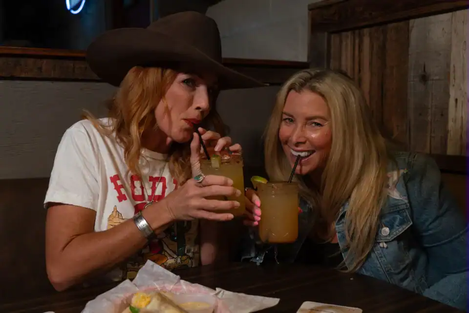 Two women enjoying their drinks at Q Bar