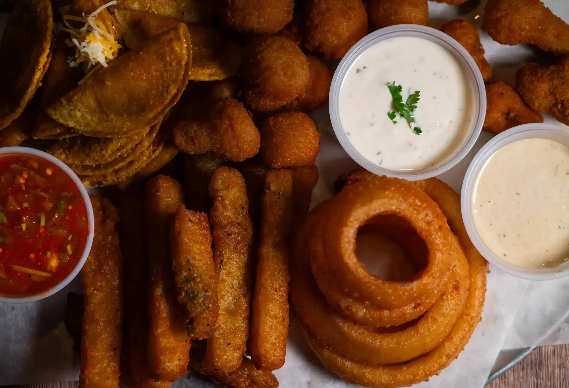 Q Platter with onion rings, fried zucchini, mini tacos, and dipping sauces